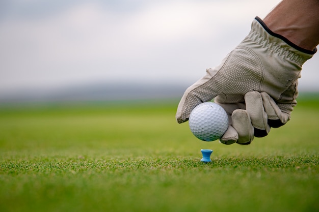 Gracz w golfa przygotowuje piłkę do wystrzelenia na polu golfowym