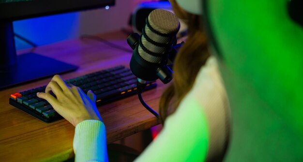 Zdjęcie gracza kobieta naciska na klawiaturę do gry w gry wideo online na komputerze ona live stream i czat z fanami