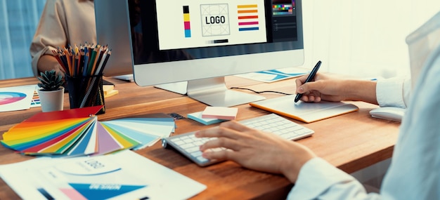 Grafik pracuje na laptopie komputerowym i graficznym piórem do rysowania podczas burzy mózgów unikalny projekt z profesjonalnym zespołem graficznym w nowoczesnym cyfrowym studiu fotograficznym Zdjęcie panoramiczne Scrutinize