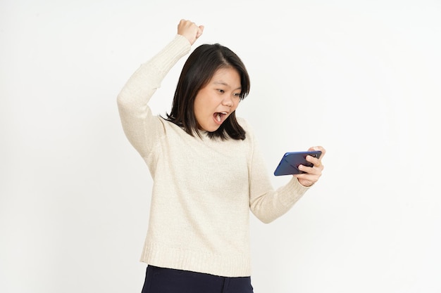Grając w grę mobilną na smartfonie pięknej azjatyckiej kobiety na białym tle
