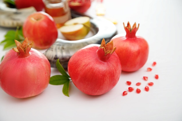 Granaty i czerwone jabłka na białym tle tradycyjne jedzenie żydowskiego Nowego Roku Rosz Haszana