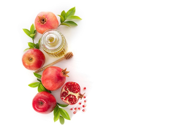 Granaty, jabłka i miód na białym tle, tradycyjne jedzenie żydowskiego Nowego Roku - Rosz Haszana. Widok z góry. Skopiuj tło przestrzeni