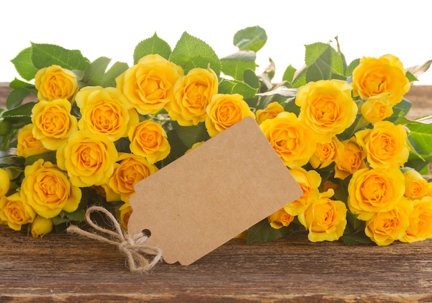 Granicy świeżych żółtych róż z pustą notatką papieru na białym tle