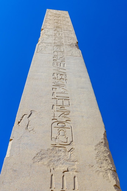 Granitowy obelisk na tle błękitnego nieba w świątyni Karnak Luxor Egipt