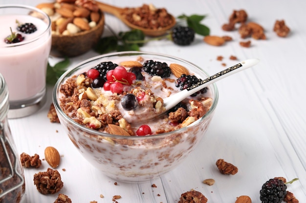 Granola chrupiące miodowe musli z jogurtem naturalnym, świeżymi jagodami, czekoladą i orzechami w misce