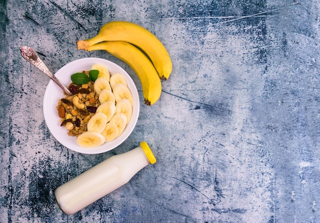 Zdjęcie granola z bananem i mlekiem na stole zbliżenie