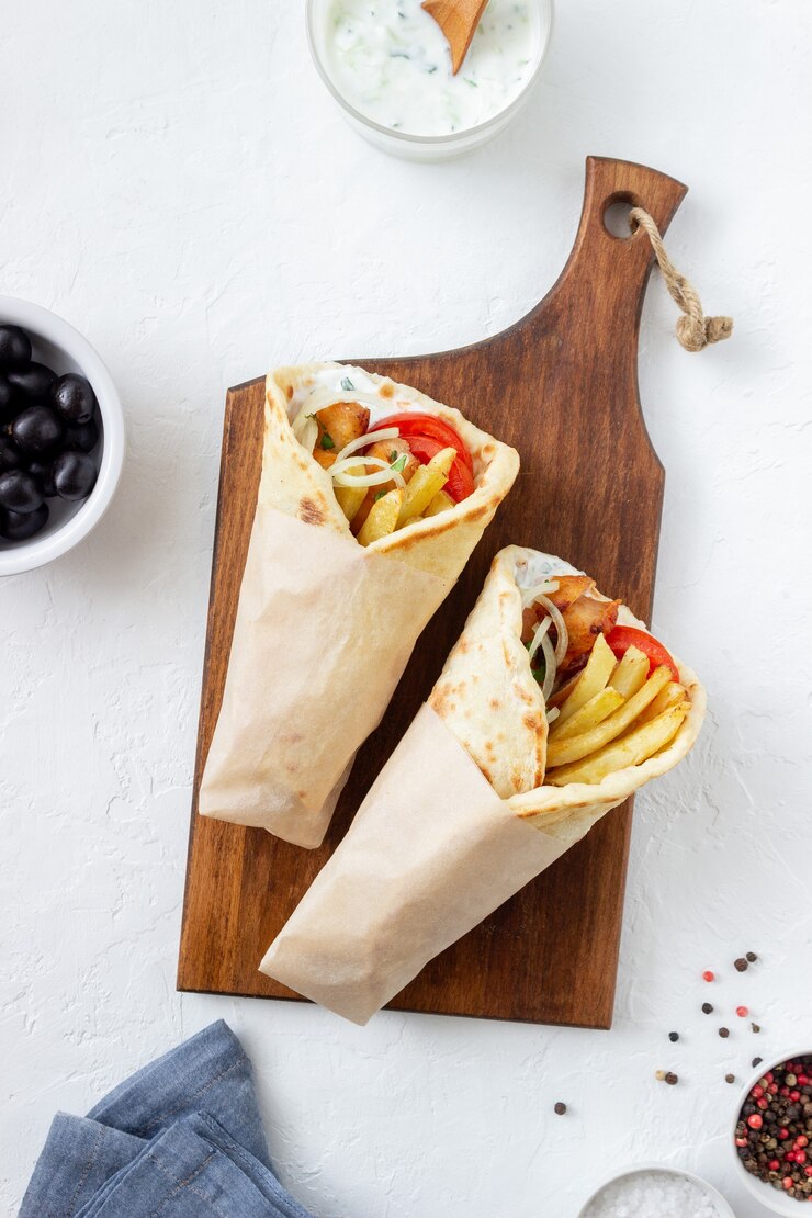 Greckie danie gyros z kurczakiem, frytkami, pomidorami, cebulą i pitą. Kuchnia grecka.