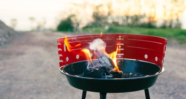 Grill na grillu płomień ognia z węglem piknikowym w przyrodzie