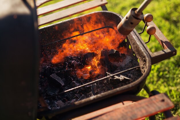 Grill rozpala ręczna latarka gazowa.