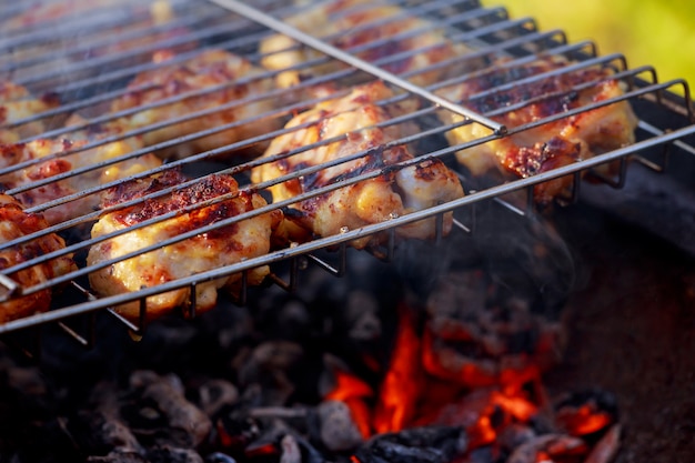 Grillowana noga kurczaka nad płomieniami na grillu.