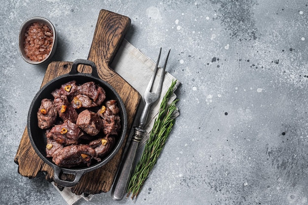 Grillowana Sauteed Pokrojona w kostkę wołowina na patelni z czosnkiem Szare tło Widok z góry Kopiowanie miejsca