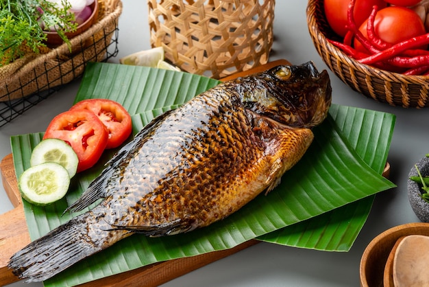 Grillowana Tilapia Lub Ikan Nila Panggang Podawane Na Liściu Bananowca I Izolowane Na Szarym Tle