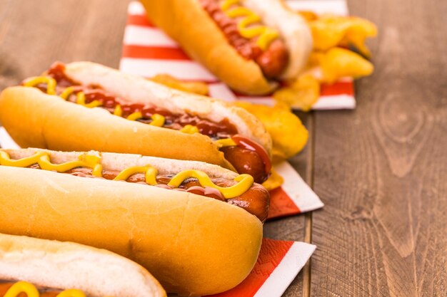 Grillowane hot dogi na bułkach z białym hot dogiem z musztardą i ketchupem.