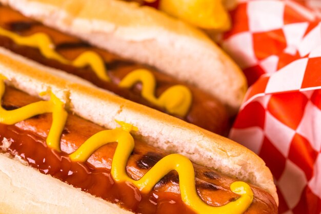 Grillowane hot dogi z musztardą i keczupem na stole z piwem z beczki.