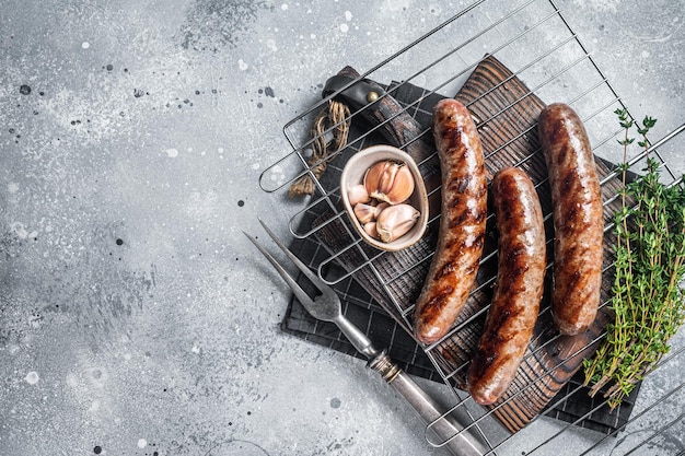 Grillowane Kiełbaski Z Mięsa Wołowego I Jagnięcego Z Ziołami Rozmarynu Na Grillu. Szare Tło. Widok Z Góry. Skopiuj Miejsce.