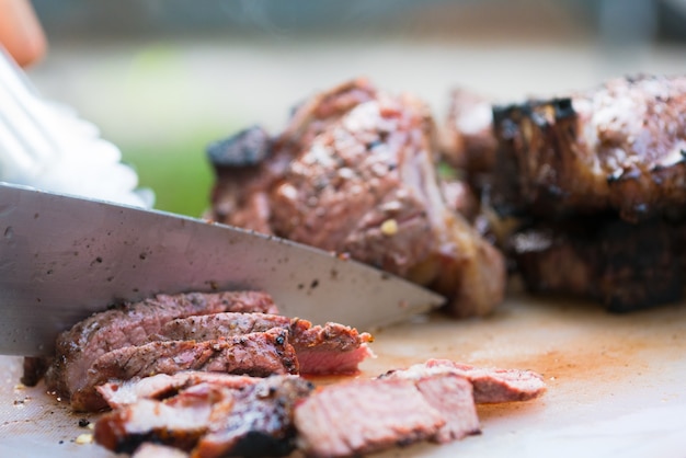 grillowane mięso pokrojone na plastikową deskę do krojenia, przyjęcie z grillem