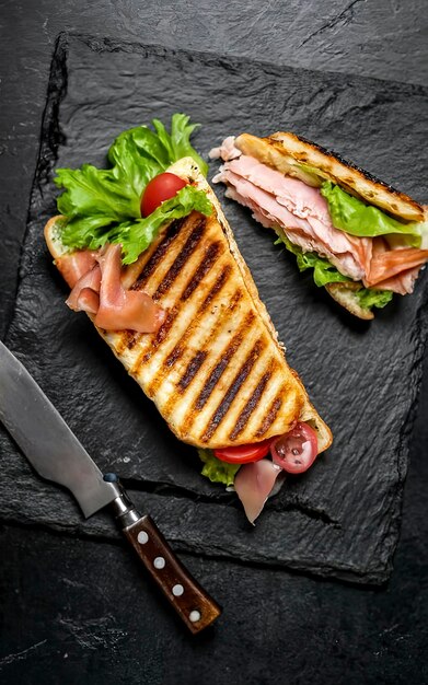 Grillowane panini z sałatką prosciutto z szynką i serem Czarne tło