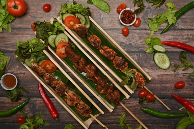Zdjęcie grillowane szaszłyki mięsne pieprz syczuański chińskie przyprawy i warzywa na drewnianym stole