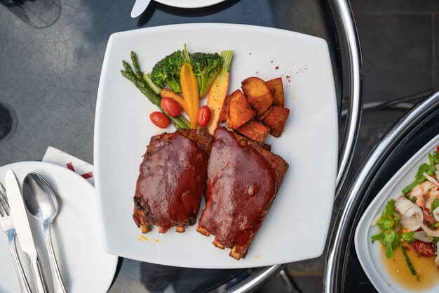 Grillowane żeberka wieprzowe polane specjalną marynatą z sosem bbq frytki i warzywa