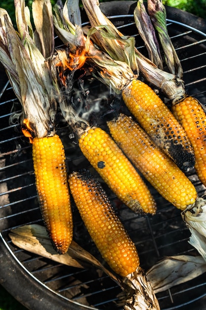Grillowanie kukurydzy w kolbie na rozżarzonym węglu w bbq