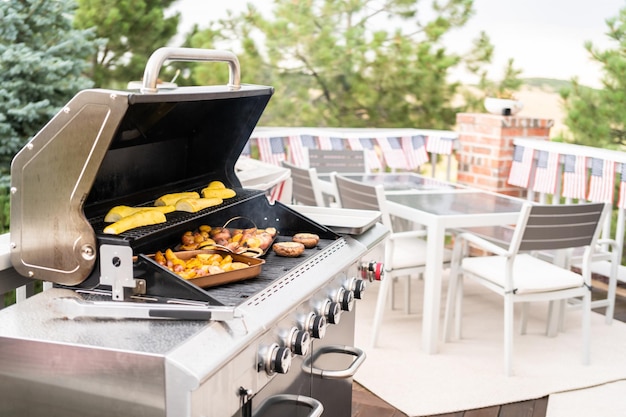 Grillowanie małych ziemniaków z plastrami czosnku na zewnętrznym grillu gazowym.