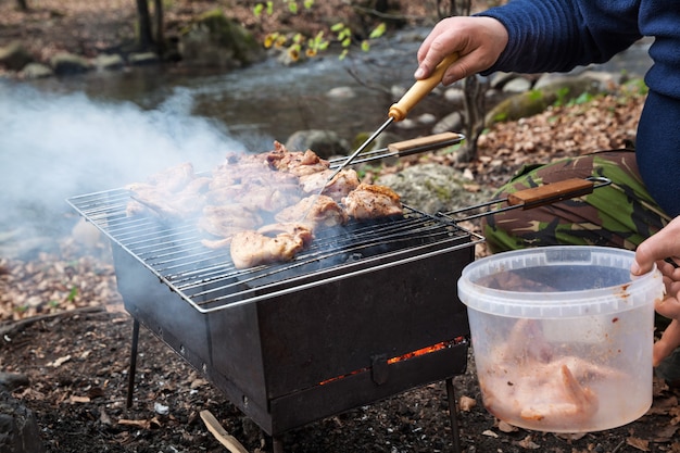 Grillowanie przyprawionego kurczaka w siatce na grillu węglowym. Płytki DOF.