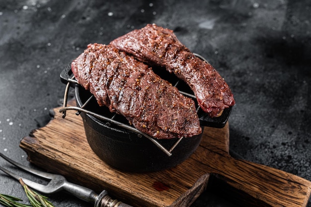 Grillowany stek ze spódnicy Machete na grillu. Czarne tło. Widok z góry.