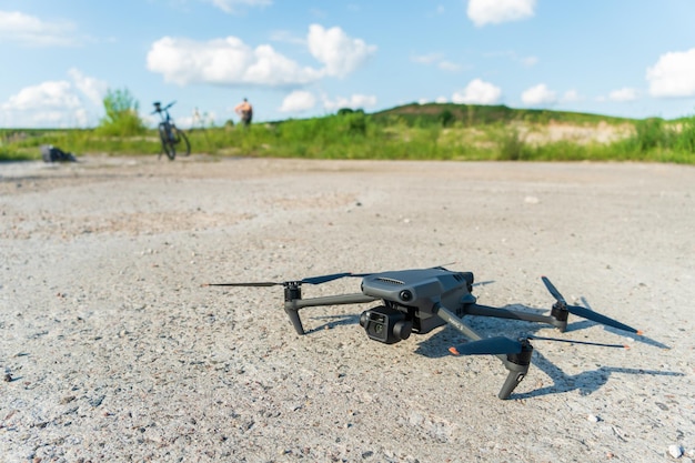 Grodno Białoruś 10 czerwca 2022 Nowy nowoczesny dron DJI MAVIC 3 leży na betonowej powierzchni z odkręconymi śrubami i przygotowuje się do pierwszego startu Najlepszy dron dla fotografa