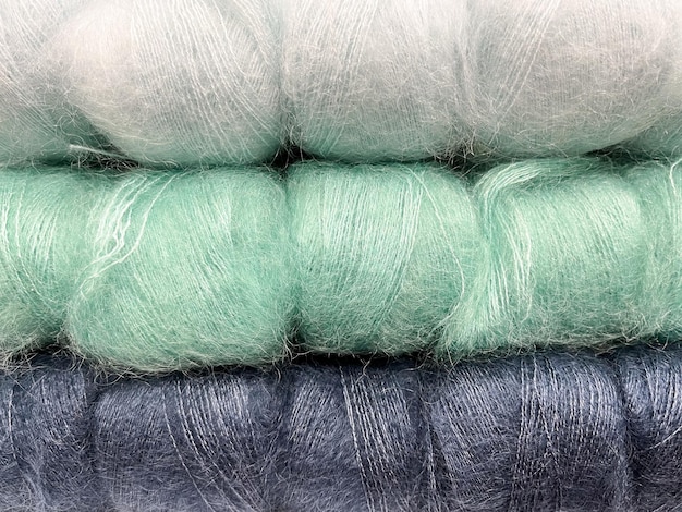 Zdjęcie gromada kolorowych puszystych sznurów do dziania i szydełkowania niebieskie i zielone sznurki z przędzy wełnianej