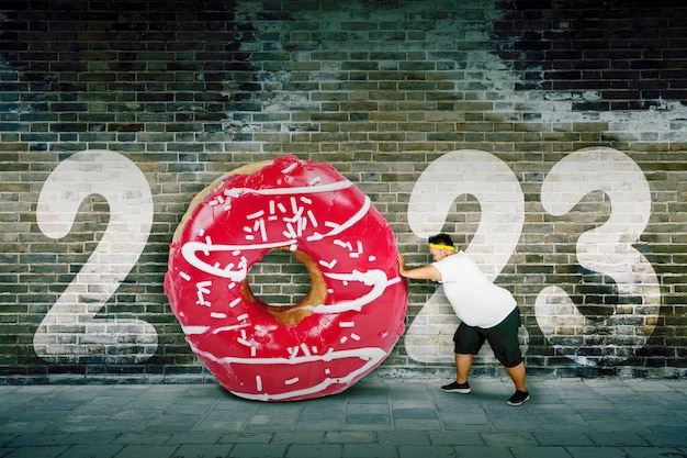 Grubas pcha duże pączki z numerem 2023