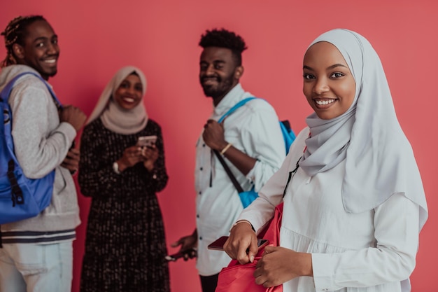 Grupa afrykańskich studentów muzułmańskich z plecakami pozujących na różowym tle. koncepcja edukacji szkolnej. Zdjęcie wysokiej jakości