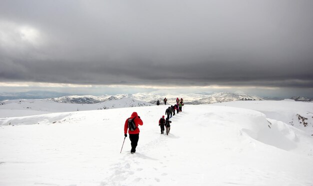 Grupa alpinistów spacerująca po górach pokrytych śniegiemxAxA