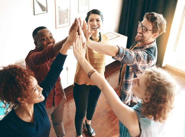 Grupa biznesmenów high five i wspólne świętowanie współpracy i sukcesu projektu w agencji Wsparcie personelu solidarność i połączenie rąk dla osiągnięć i współpracy z zaufaniem
