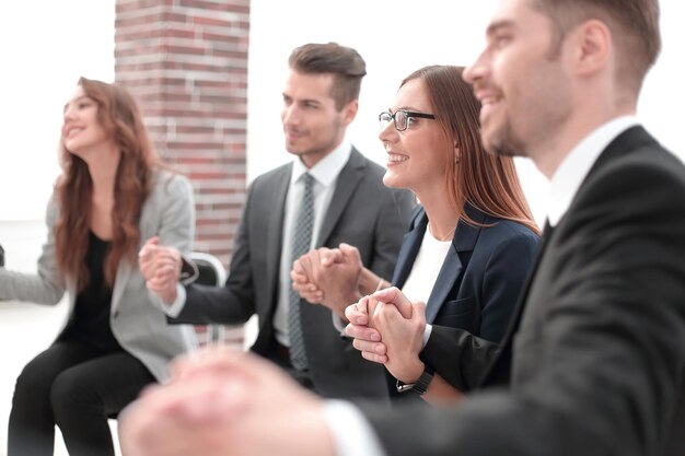 Grupa biznesmenów trzymających się za ręce w kręgu