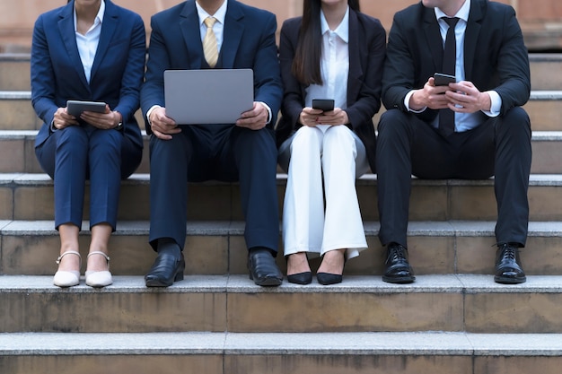 Grupa Czterech Biznesmenów Siedzi Z Telefonami I Komputerem