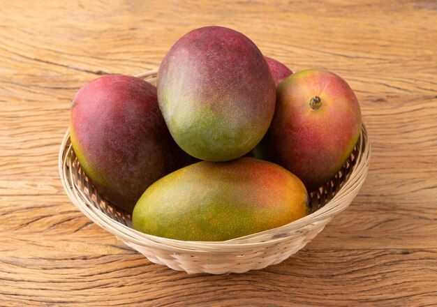 Grupa dojrzałych mango nad drewnianym stołem