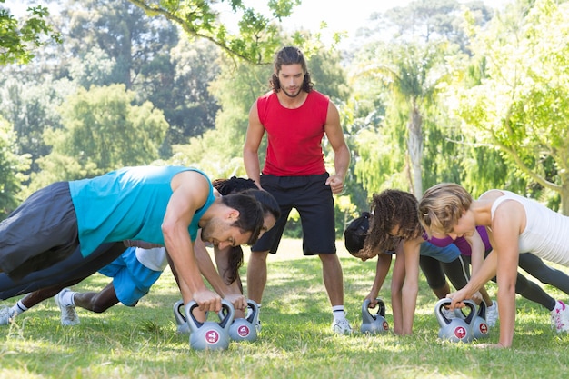 Grupa fitness deskowanie w parku z trenerem