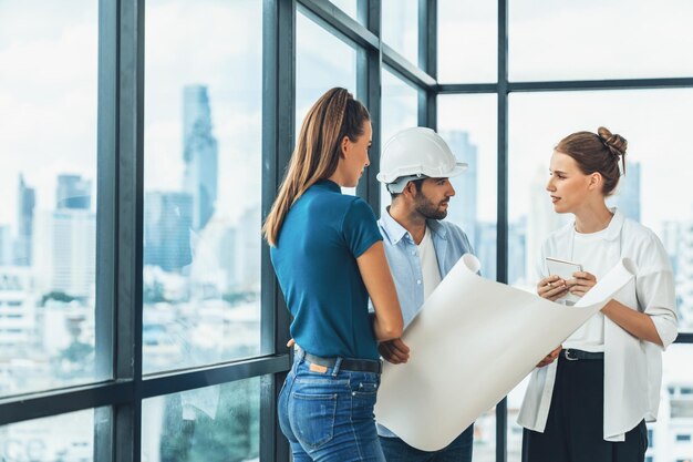 Grupa inżynierów architektów patrzących na plan projektu podczas burzy mózgów pomysł na strukturę budynku Zespół menedżera dyskutuje o budowie budynku stojąc w pobliżu z widokiem na miasto Tracery