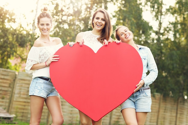Zdjęcie grupa kobiet trzymających wielkie serce na zewnątrz