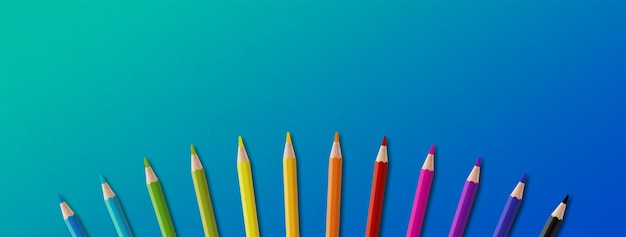 Grupa kolorowych ołówków wyizolowanych na niebiesko Panoramiczne tło transparentu