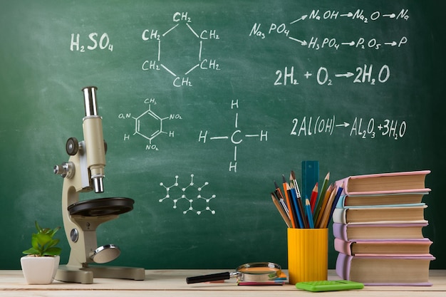 Grupa koncepcyjna edukacji i nauki kolorowych książek i mikroskopu na drewnianym stole w klasie