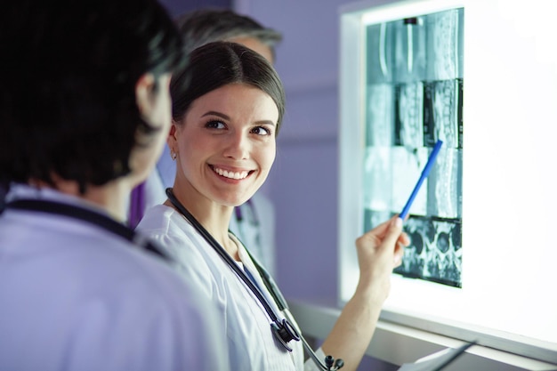 Grupa lekarzy badających zdjęcia rentgenowskie w klinice z myślą o postawieniu diagnozy