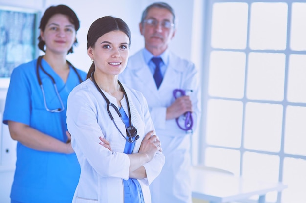 Grupa lekarzy i pielęgniarek stojących w sali szpitalnej