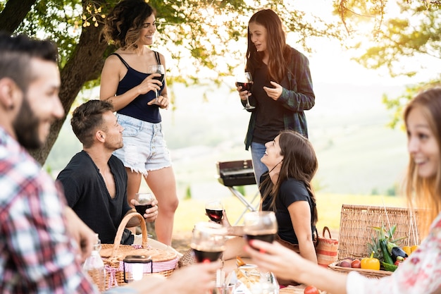 Zdjęcie grupa ludzi bawiących się jedzeniem i piciem wina na pikniku na świeżym powietrzu