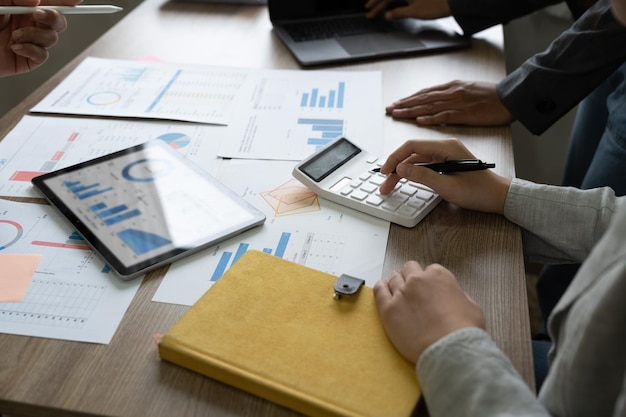 Grupa ludzi biznesu analizuje podsumowujące raporty wykresów wydatków operacyjnych firmy i danych roboczych dotyczących sprawozdań finansowych firmy