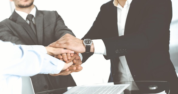 Grupa ludzi biznesu pokazująca pracę zespołową i łącząca ręce jako koło w nowoczesnym biurze Koncepcja sukcesu