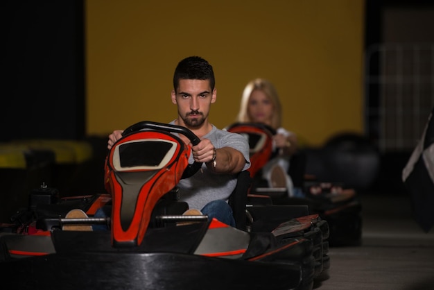 Grupa ludzi jedzie samochodem GoKart z prędkością na placu zabaw Tor wyścigowy Go Kart to popularny sport rekreacyjny
