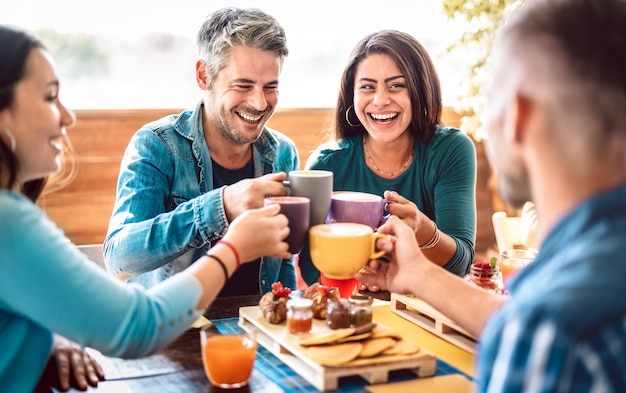 Grupa Ludzi Opiekających Latte Na Dachu Kawiarni - Przyjaciele Rozmawiają I Bawią Się Razem W Restauracji Cappuccino - Koncepcja Stylu życia Ze Szczęśliwymi Mężczyznami I Kobietami Na Tarasie Kawiarni - Jasny, Ciepły Filtr