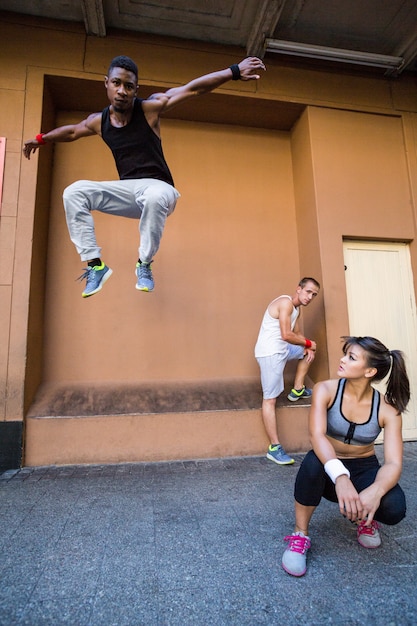 Grupa ludzi robi parkour w mieście