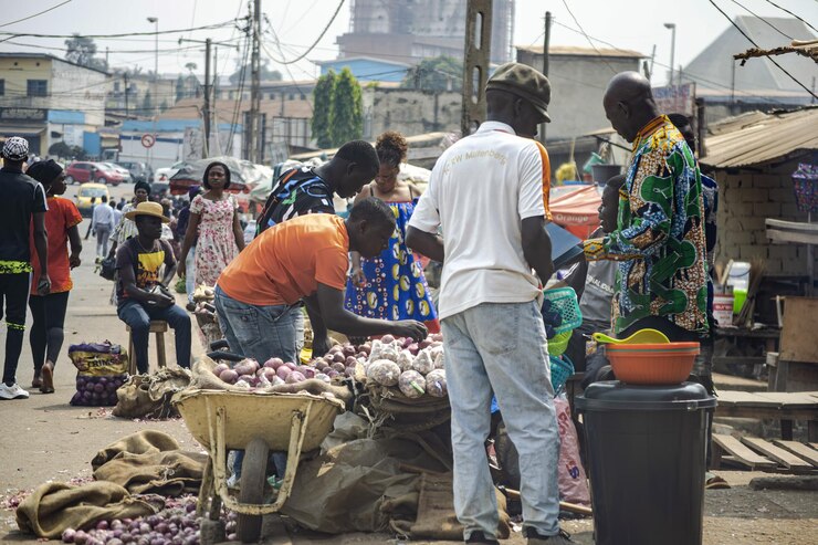 Grupa ludzi robiących zakupy na targu Nkoleton z mnóstwem warzyw Yaounde Kamerun